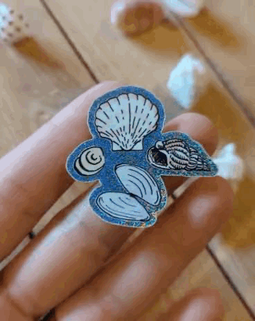 Sticker brillant « 4 coquillages » sous un autre angle, reflets bleutés