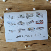 Couverture du calendrier 2027 « D'île en île » posée sur une table parmi des coquillages