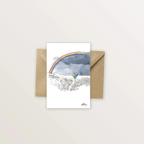 Carte postale « Arc-en-ciel » : arc-en-ciel au-dessus d'un paysage dessiné à l'encre, avec enveloppe kraft