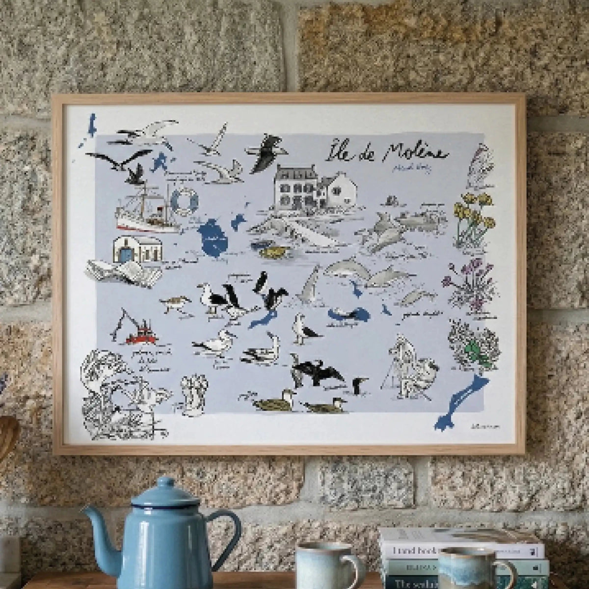 Affiche Île de Molène encadrée sur un mur de pierre, au-dessus d'une théière émaillée