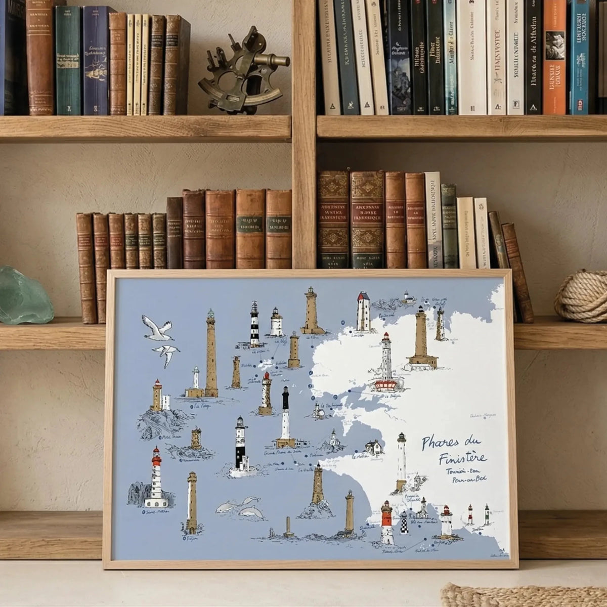 Affiche Phares du Finistère encadrée devant une bibliothèque